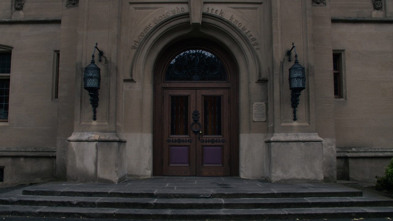 The grand carved doors of the YTC Global Learning Center, engraved above with &lsquo;Welcome those who seek knowledge&rsquo;