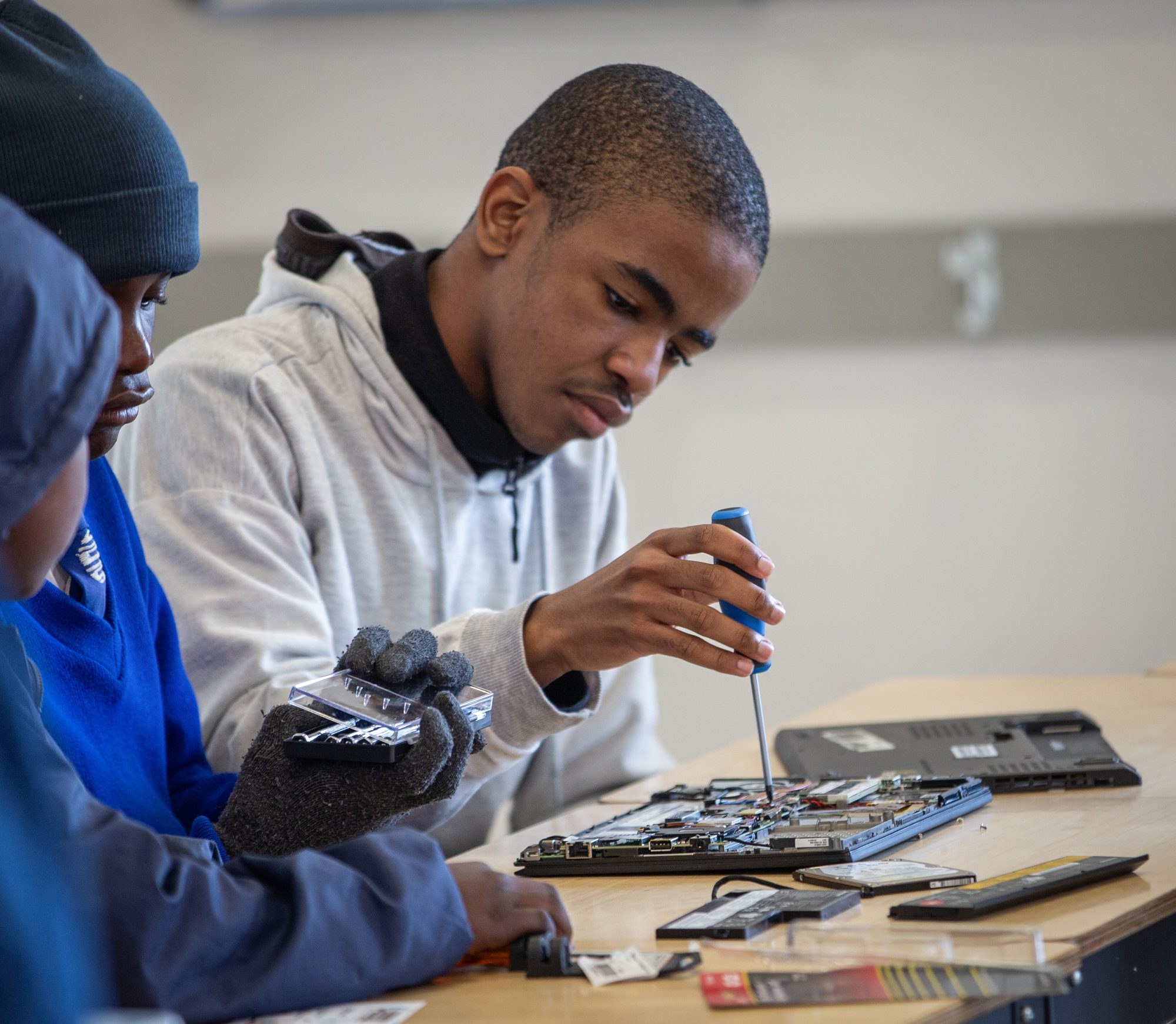 A student repairing an open computer at the workbench