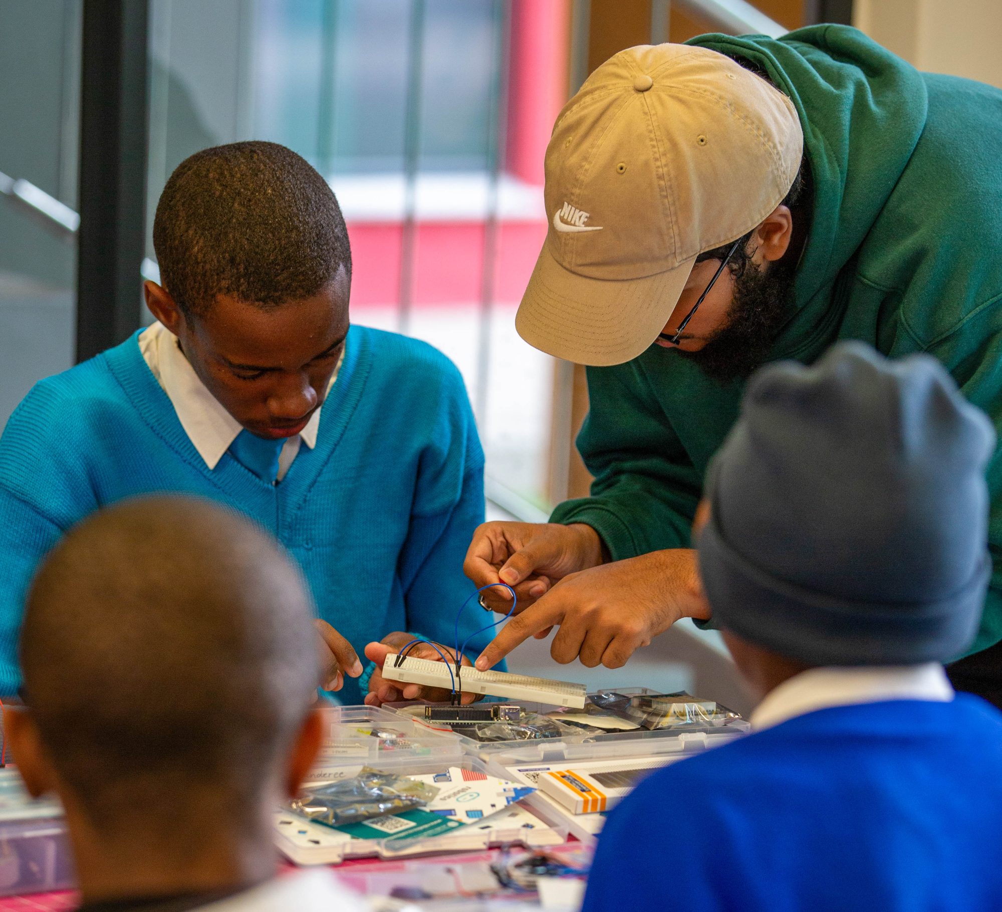 Furqaan I. guiding students through a hands-on robotics exercise in Namibia