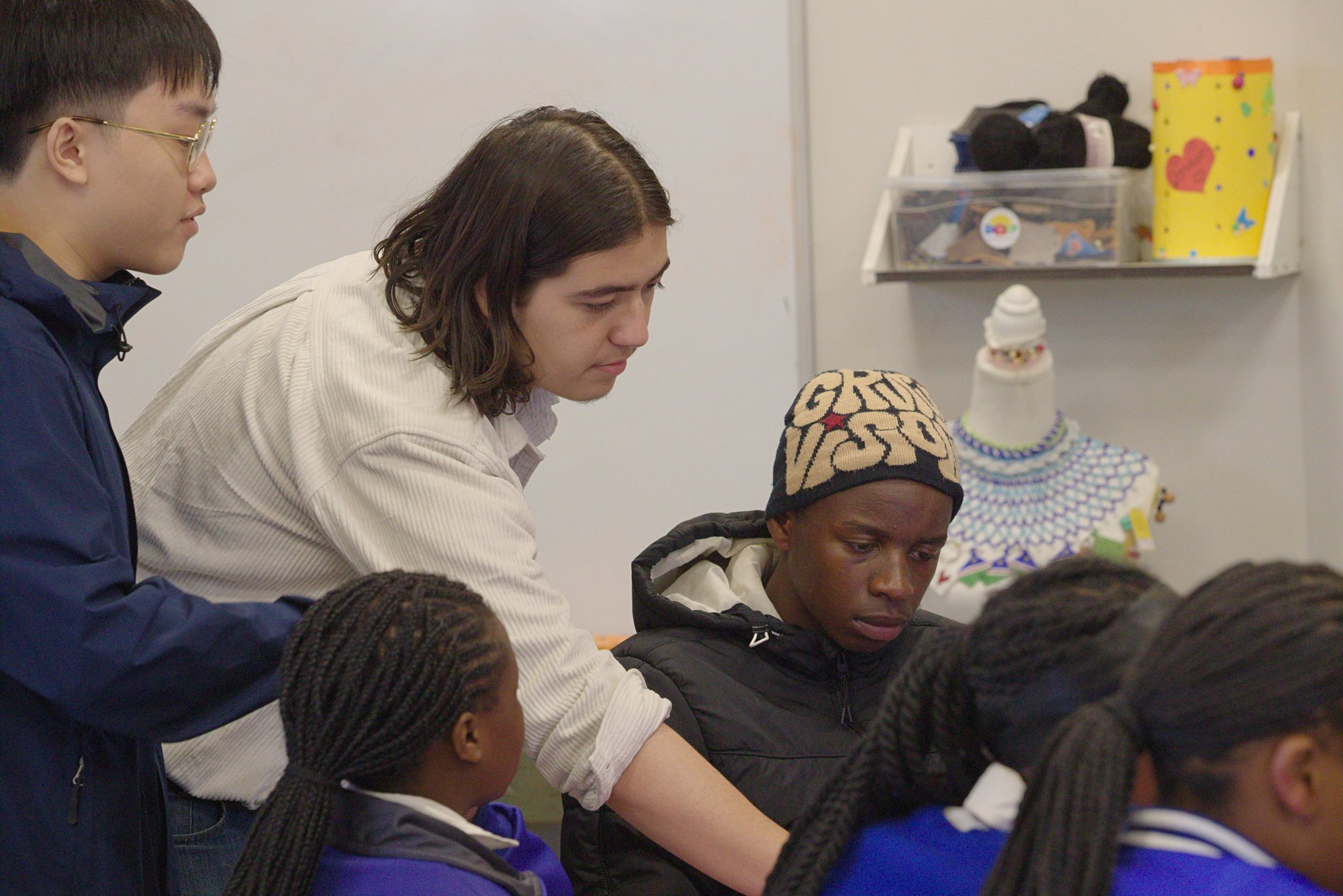 Chris Gutierrez and Allen Tieng helping a student during a robotics lesson in Namibia